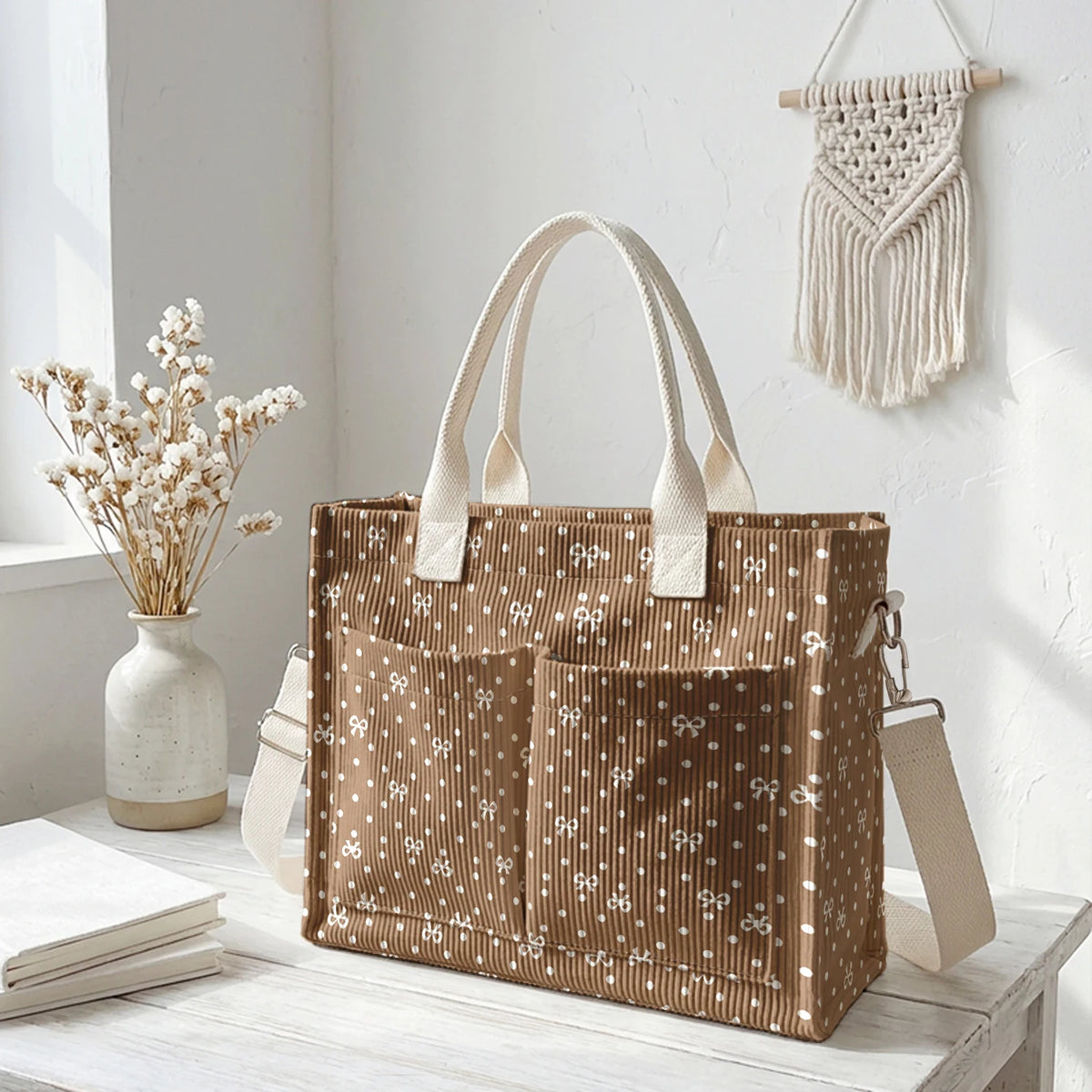 Sac cabas en velours côtelé marron à pois blancs et anses beige clair, exposé sur une surface en bois blanc.