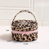 Bolsa de maquillaje redonda con estampado de leopardo y cremallera rosa, mostrada sobre fondo blanco.