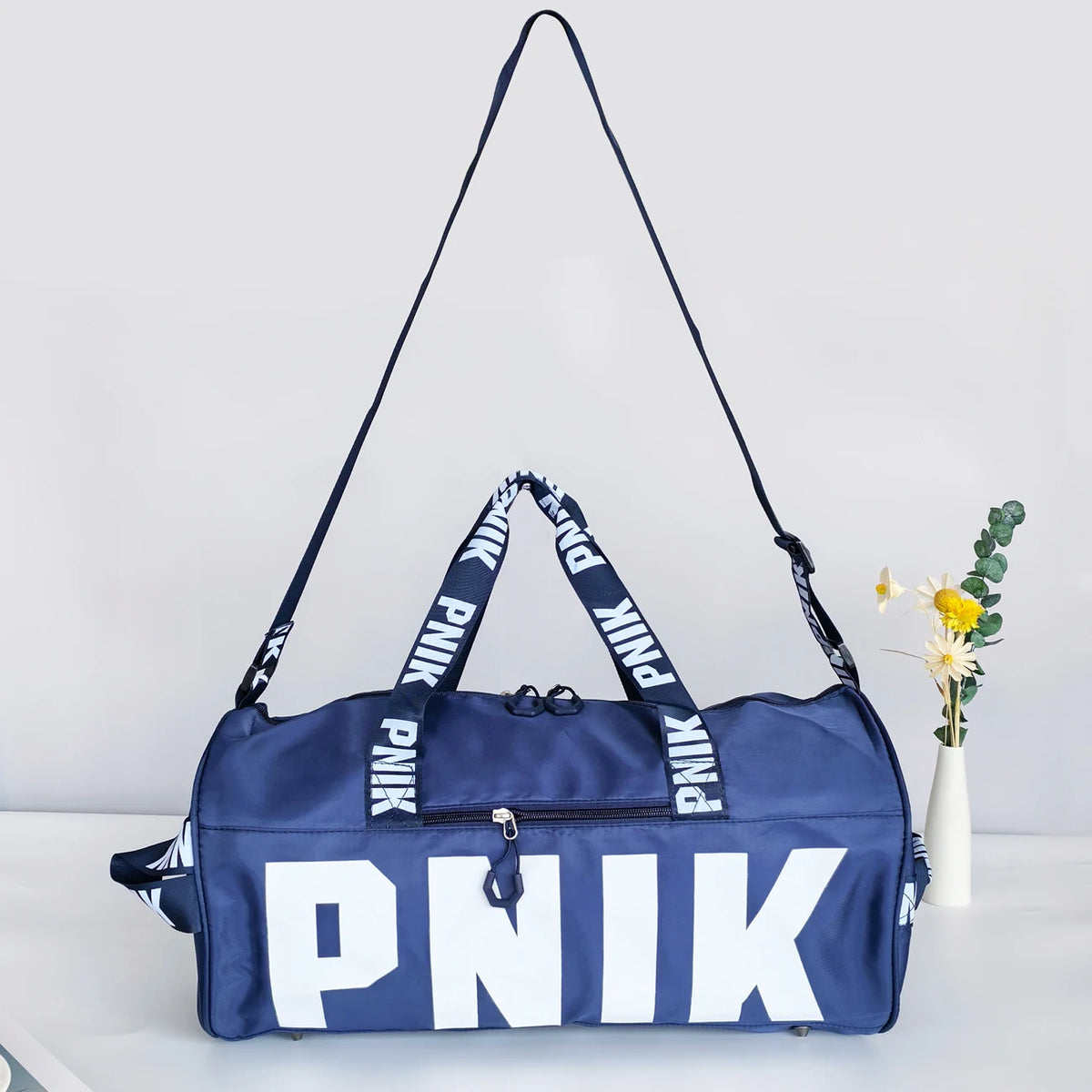 A navy blue Nike shoulder bag with white lettering is displayed on a white surface.