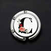 Silver metal letter C hanger hook with a pink rose floral design on a black background