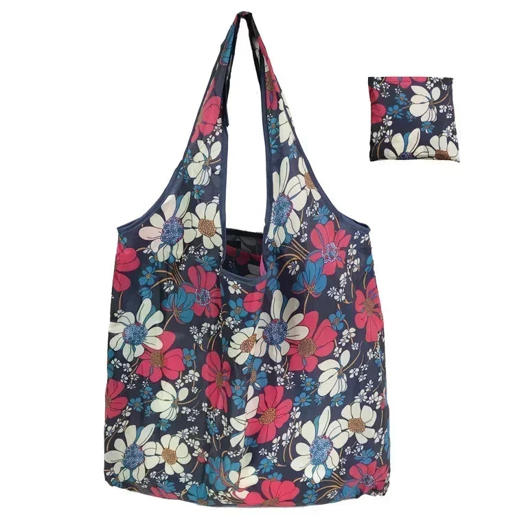 A reusable fashion shopping tote bag featuring a floral print with pink, blue, and white flowers.