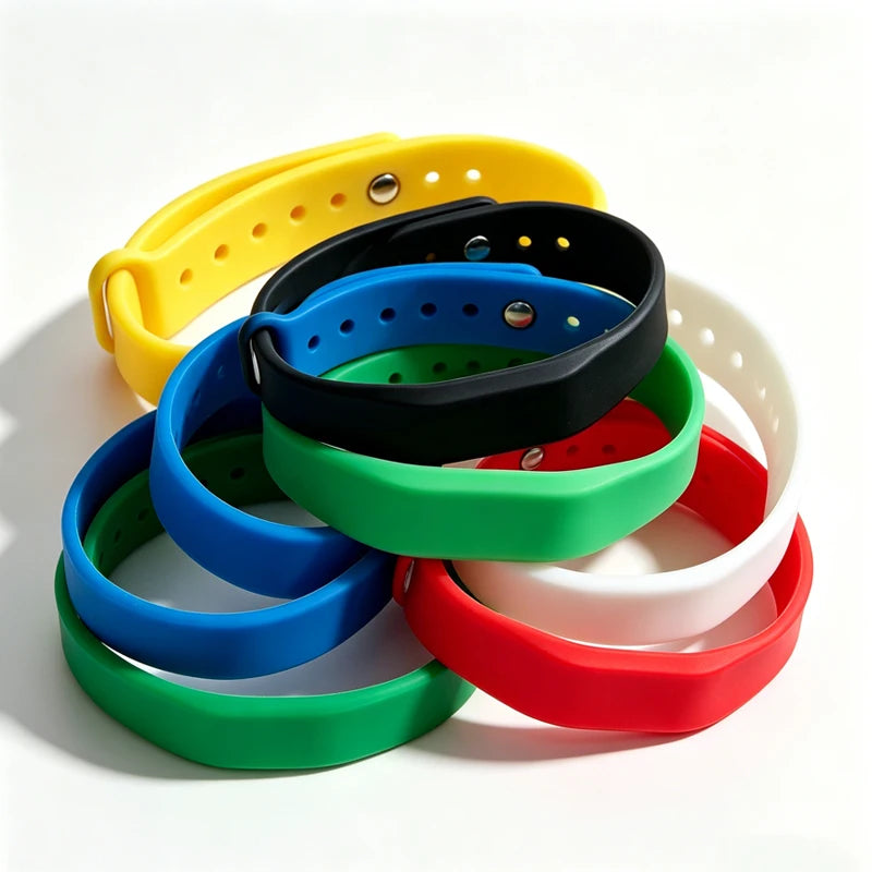 Une pile de bracelets en silicone colorés jaune, noir, bleu, vert, rouge et blanc.