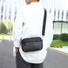 A man wearing a white shirt and dark pants carrying a black PU leather shoulder clutch bag on his back.