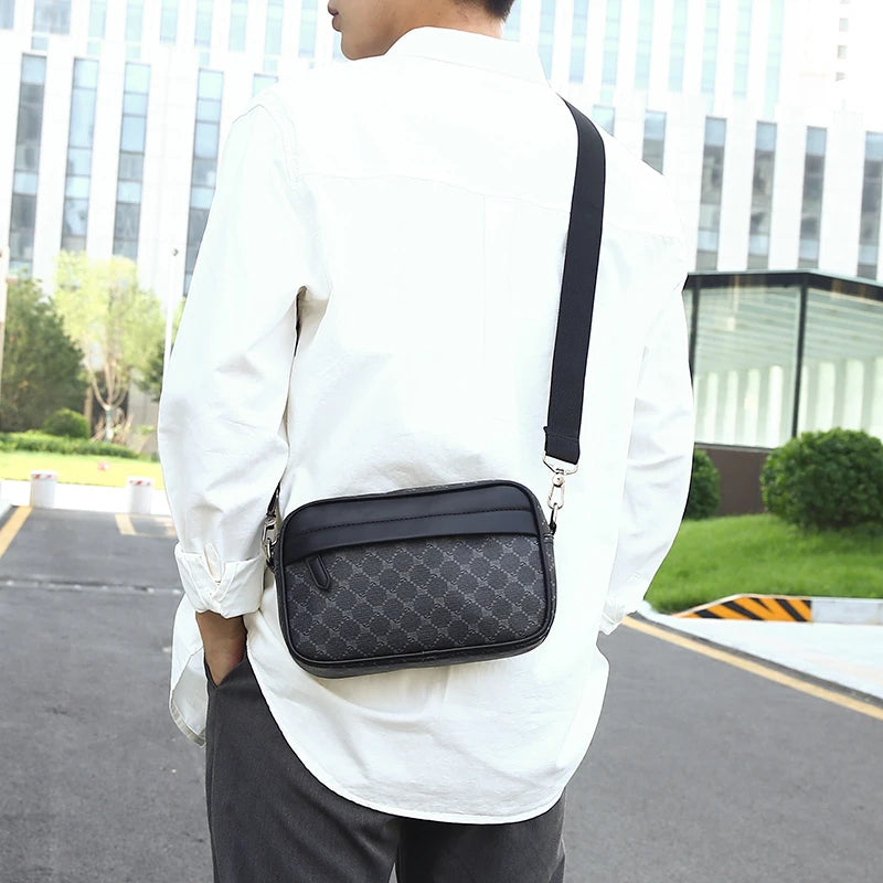 A man wearing a white shirt and dark pants carrying a black PU leather shoulder clutch bag on his back.