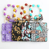 A silicone bead and leather card wallet featuring colorful beads and patterned leather sections.