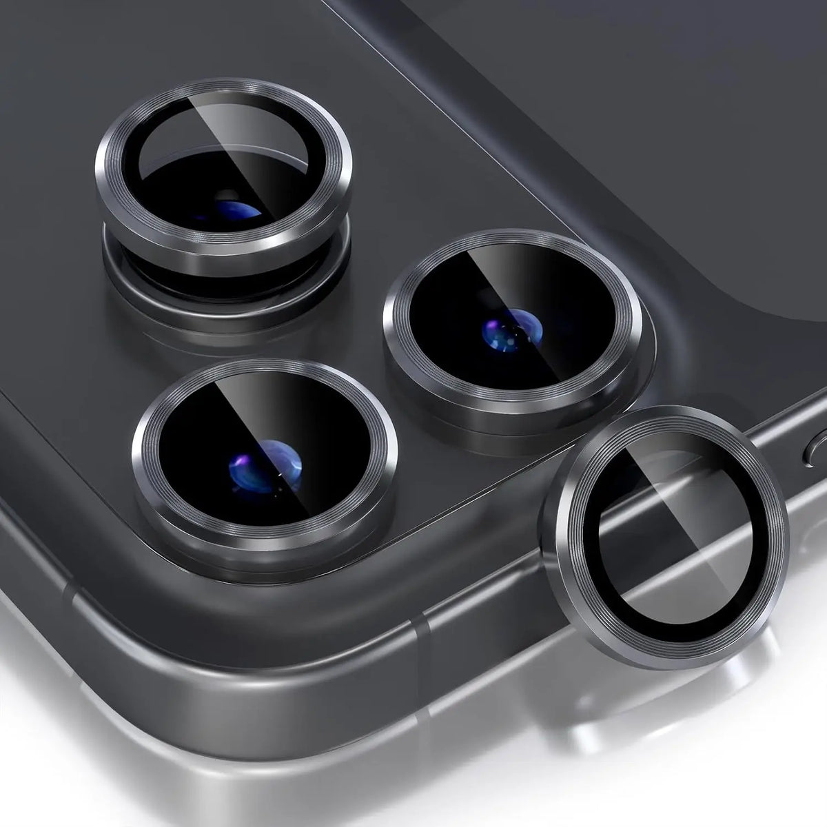 A close-up view of a glitter diamond camera lens protector with a metal frame for an iPhone, showing four lenses.