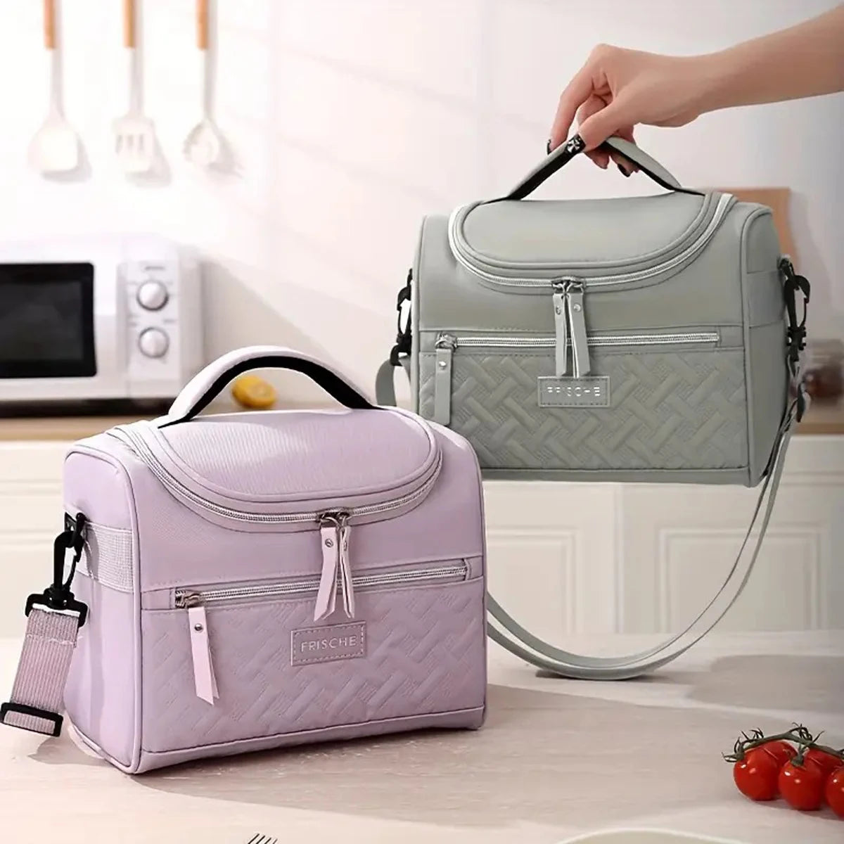 Una bolsa térmica de color verde claro con correa acolchada para el hombro, mostrada sobre una mesa.