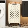 A tall, cream-colored foldable laundry basket with a diamond pattern is shown next to a white appliance and a dark cabinet.