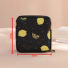 Black compact pouch with a yellow lemon pattern used for storing sanitary pads or tampons.