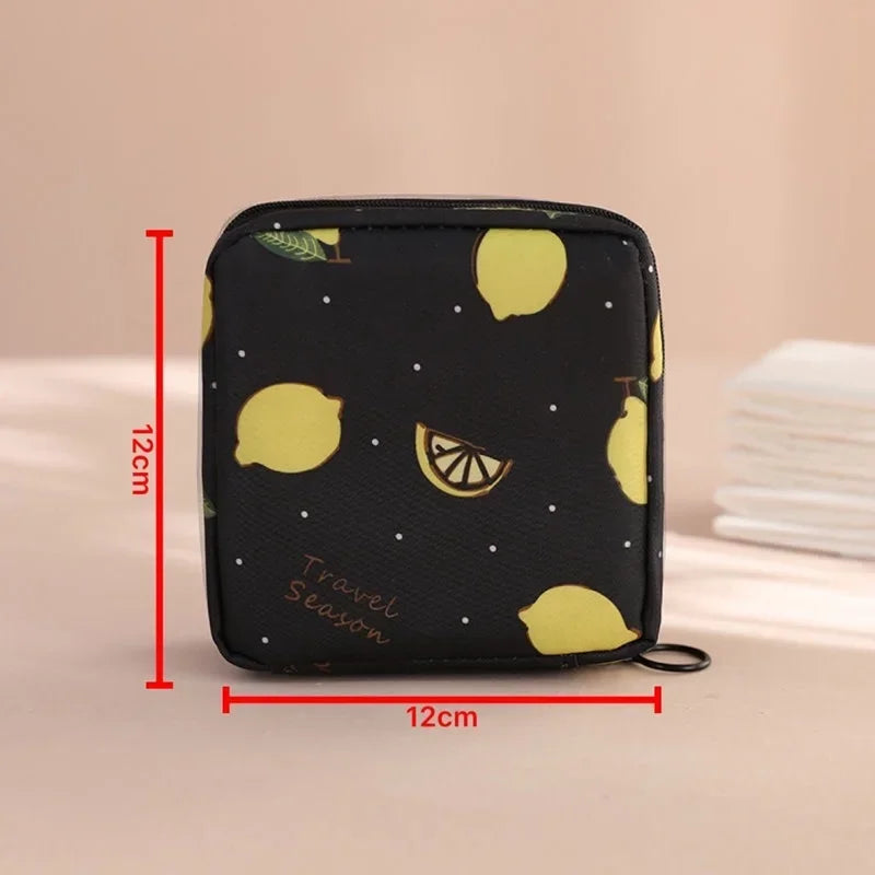 Black compact pouch with a yellow lemon pattern used for storing sanitary pads or tampons.