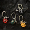 A set of resin dice keychains featuring red, green, and yellow dice with silver clasps.