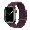 A dark gray Apple Watch is shown on a purple braided stretch band.