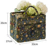 A quilted fabric storage basket with carry handles featuring a dark green and blue floral pattern.