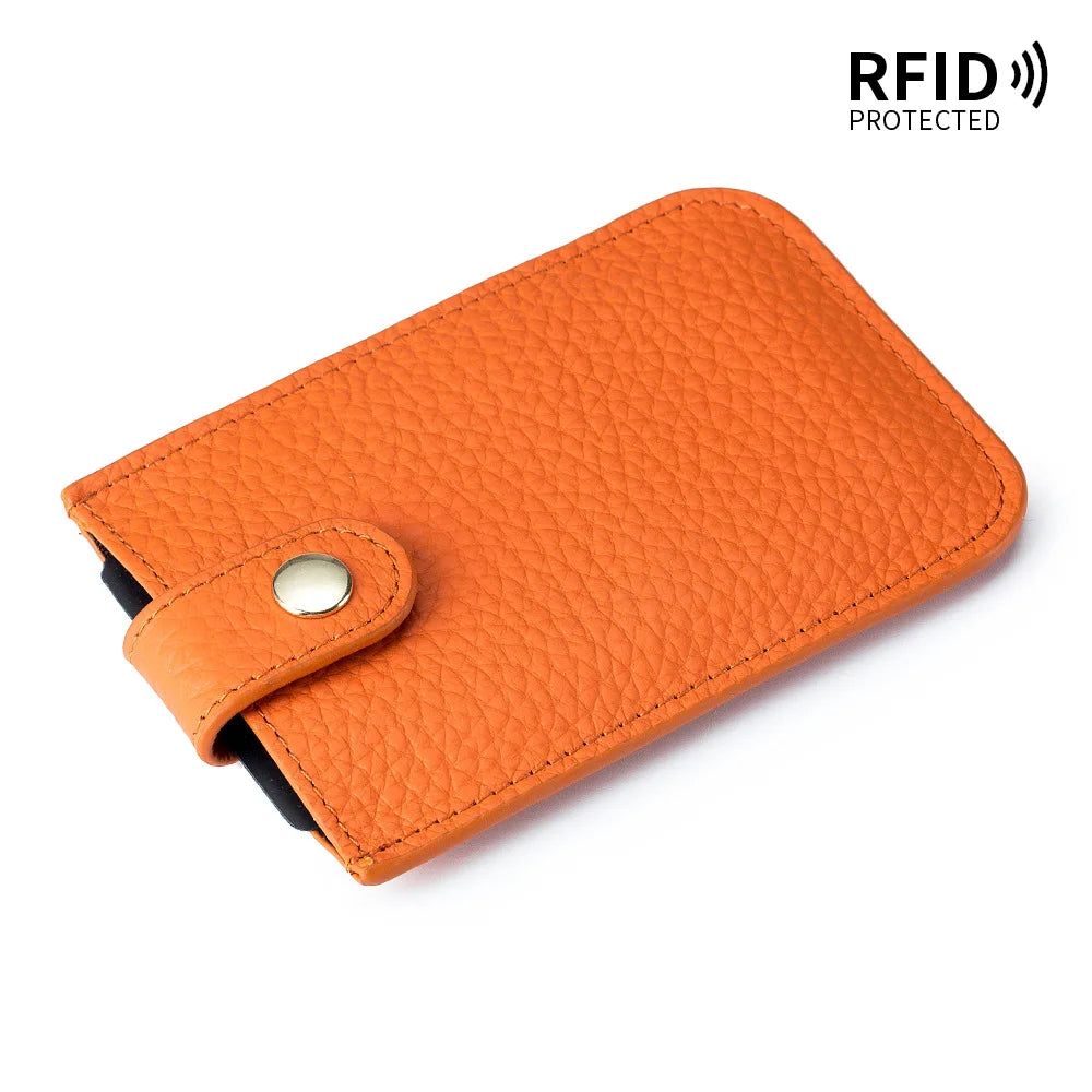 An orange genuine leather slim card holder with a black lining and RFID protection feature.