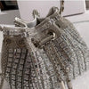 Silver crystal-embellished evening clutch featuring intricate chains and detailed embellishments.