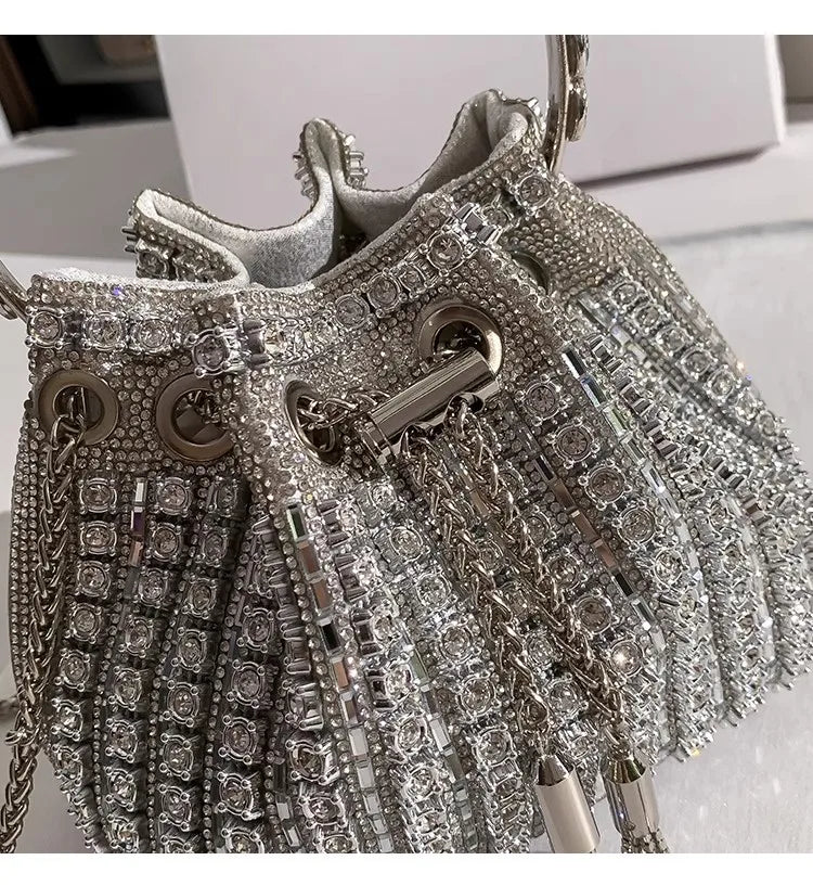 Silver crystal-embellished evening clutch featuring intricate chains and detailed embellishments.