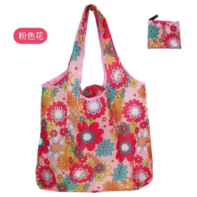 A pink reusable eco tote shopping bag featuring a floral pattern with red, orange, and green accents.