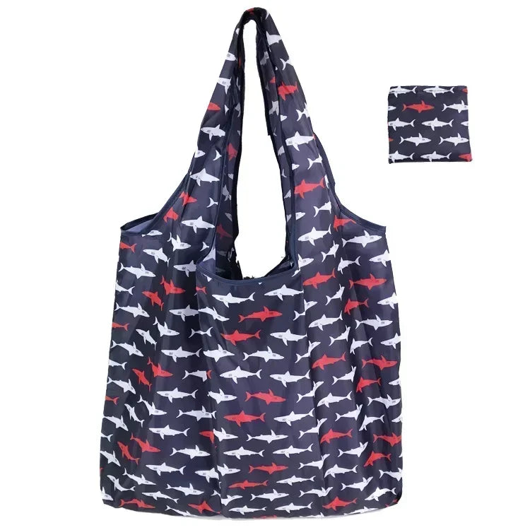 A navy blue tote bag with a floral print featuring small red and white fish patterns.