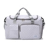 A light gray quilted portable travel duffle bag with padded compartments and carrying handles.