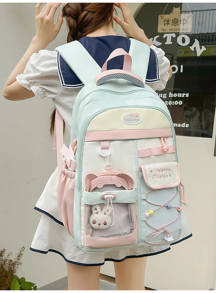 A woman is wearing a light blue and white Candy Color Campus backpack on her back.