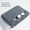 A gray multi-pocket laptop sleeve organizer with a front pocket and handle, shown next to a silver laptop.