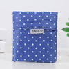 A folded blue reusable supermarket shopping bag with white polka dots.