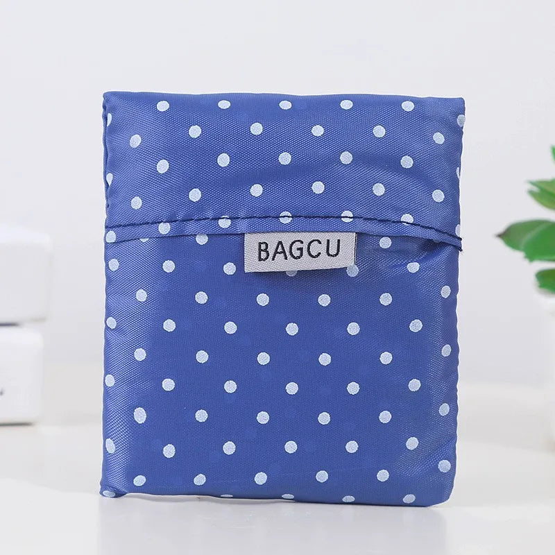A folded blue reusable supermarket shopping bag with white polka dots.