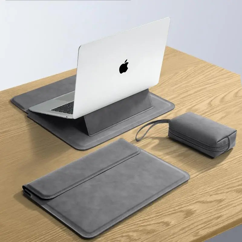 A gray premium PU laptop sleeve is shown next to an Apple laptop and a matching sleeve on a wooden surface.