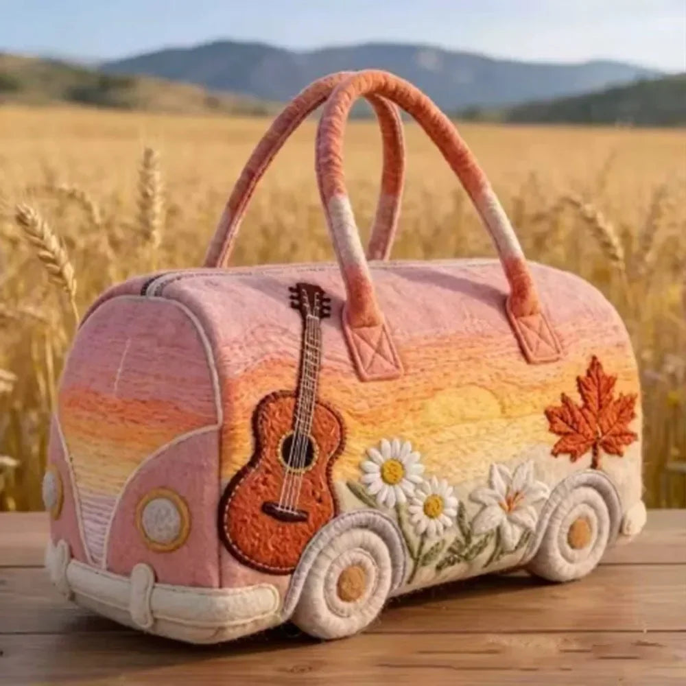 A quilted travel duffle bag in soft peach and orange tones with a wooden guitar design set against a golden field background.