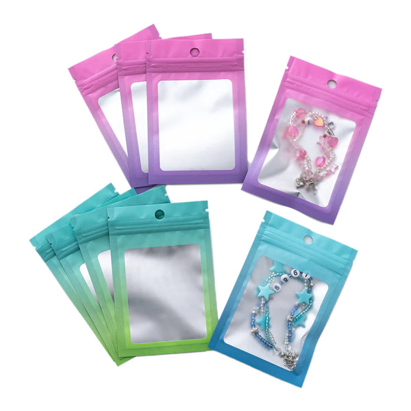 A collection of resealable gradient storage bags in pink, purple, and teal holding jewelry and supplies.