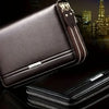 A dark brown leather mens long zipper wallet clutch with silver accents shown in a close-up view.