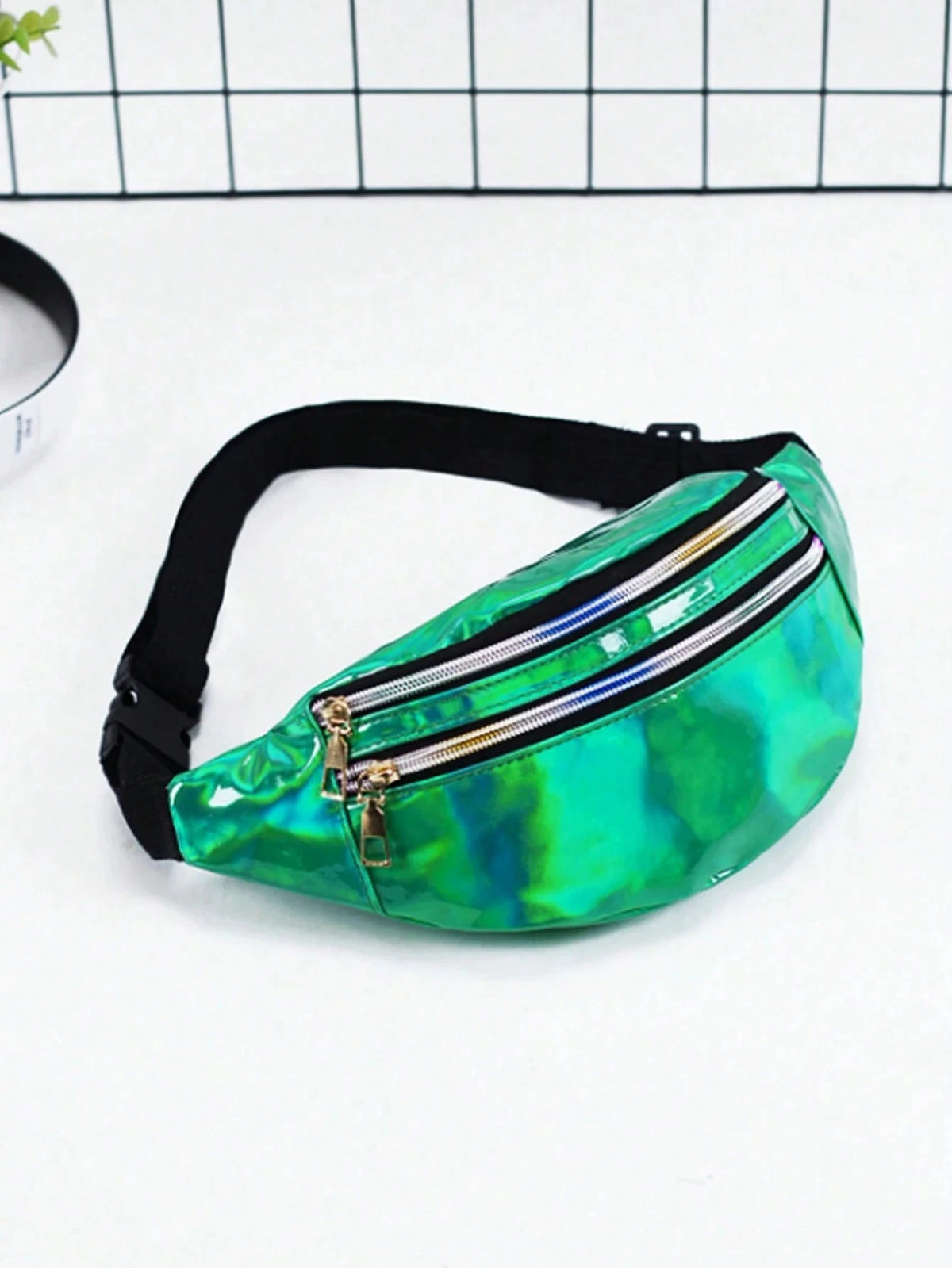 A vibrant holographic green sequin waist bag with a silver zipper and black adjustable strap.