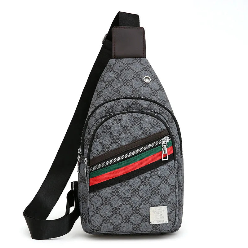 A gray patterned printed crossbody sling bag with a brown leather strap and zipper details.
