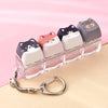 A set of nine acrylic cat keycaps in various colors and shades displayed on a clear plastic tray with a silver bag charm.