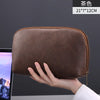 A brown leather multi-layer cable organizer pouch is held in a hand, showing its size and texture.