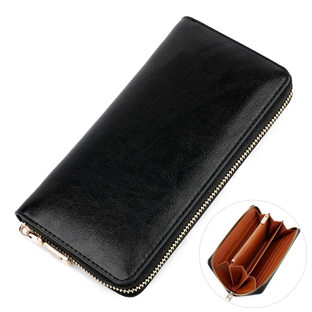 A black genuine leather zipper wallet shown from above with a gold-colored zipper detail.