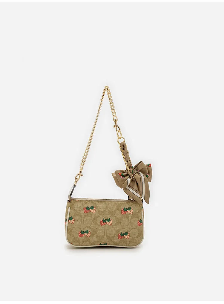 A beige fabric bow bag with a chain strap and a fabric bow detail.