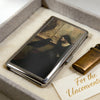An Art Deco metal card holder with a dark photograph resting in a light-colored box.