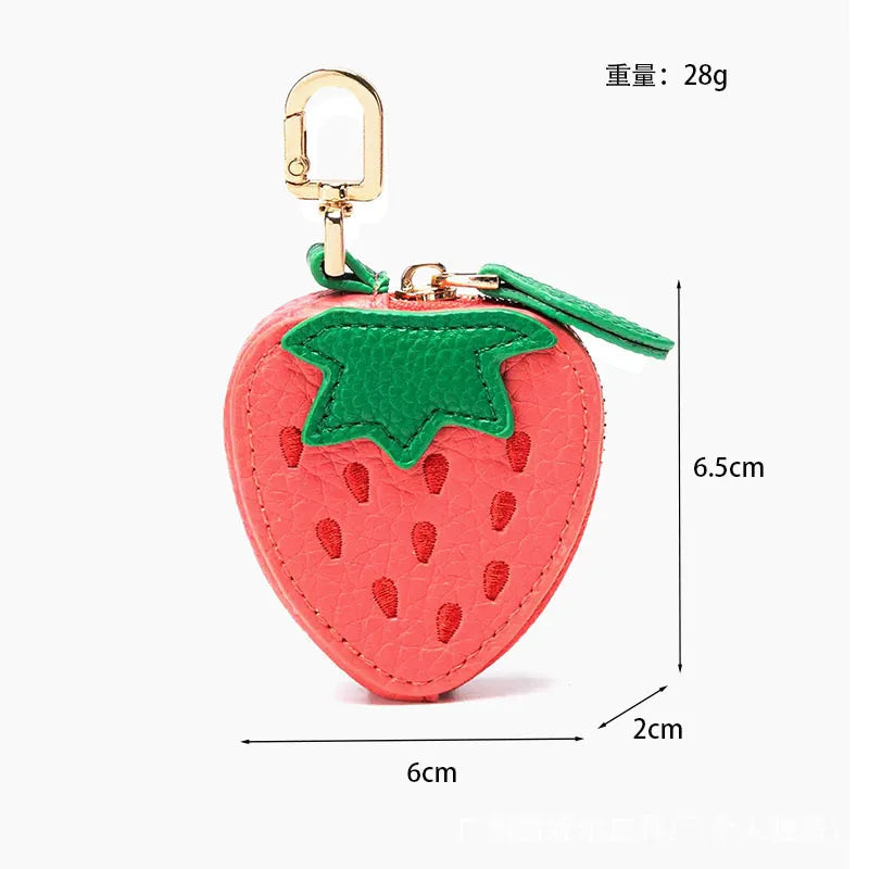 A red strawberry shaped PU leather coin purse keychain with a green leaf detail and gold-colored clasp.