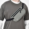 Una camiseta gris con una bolsa para dinero de RFID bloqueante negra adjunta a la camiseta.