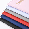A stack of elegant PU leather passport holder wallets in various colors including pink, white, gray, and blue.