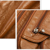 Close-up of a brown leather tote bag showing stitching and hardware details.