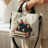 Beige Tasche mit Blumen-Katzenmuster, schwarzem Katzengesicht und orangefarbener Umhängetasche.