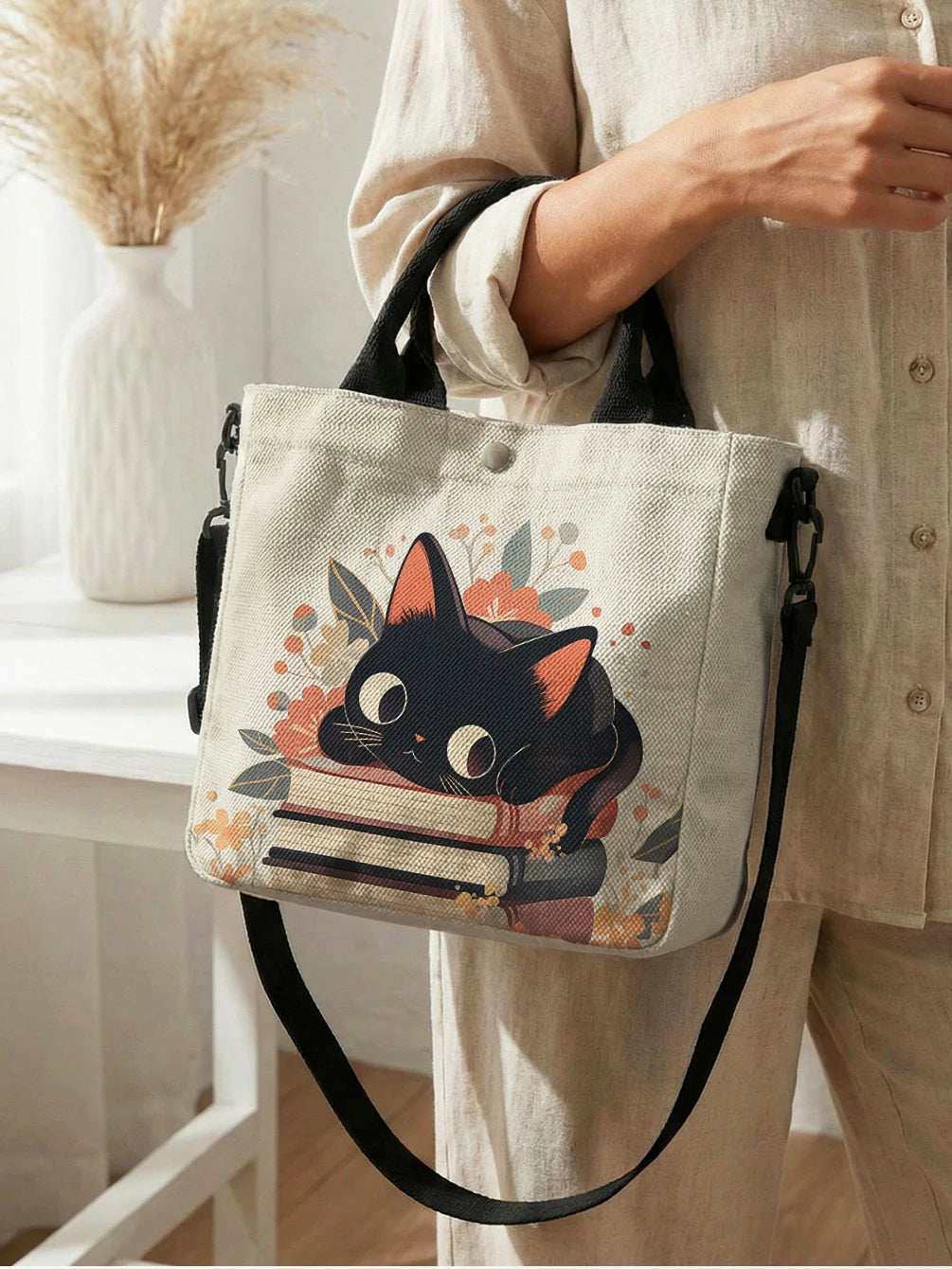Beige Tasche mit Blumen-Katzenmuster, schwarzem Katzengesicht und orangefarbener Umhängetasche.