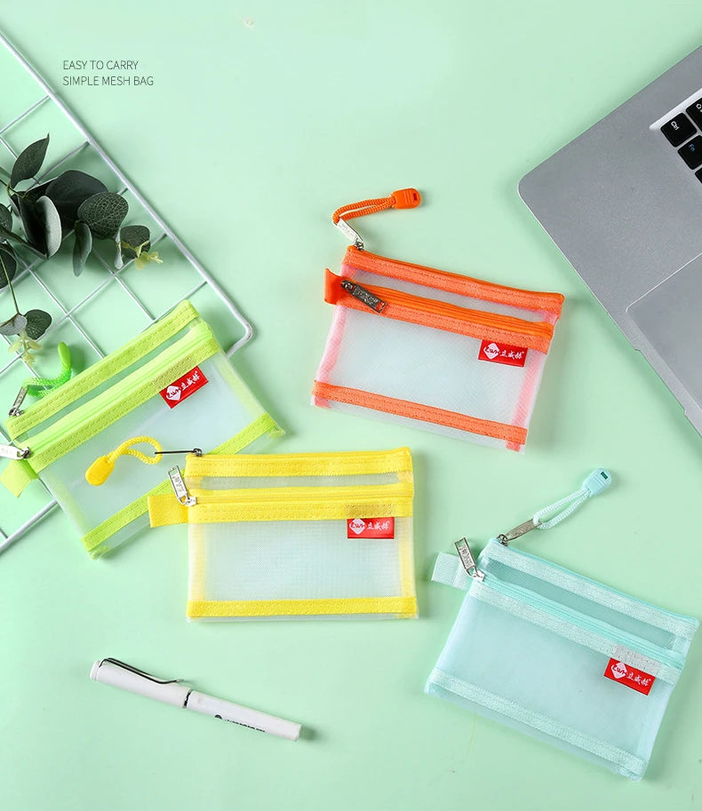 A set of clear mesh bags in yellow and orange for storing coins and cards, displayed on a light green surface.