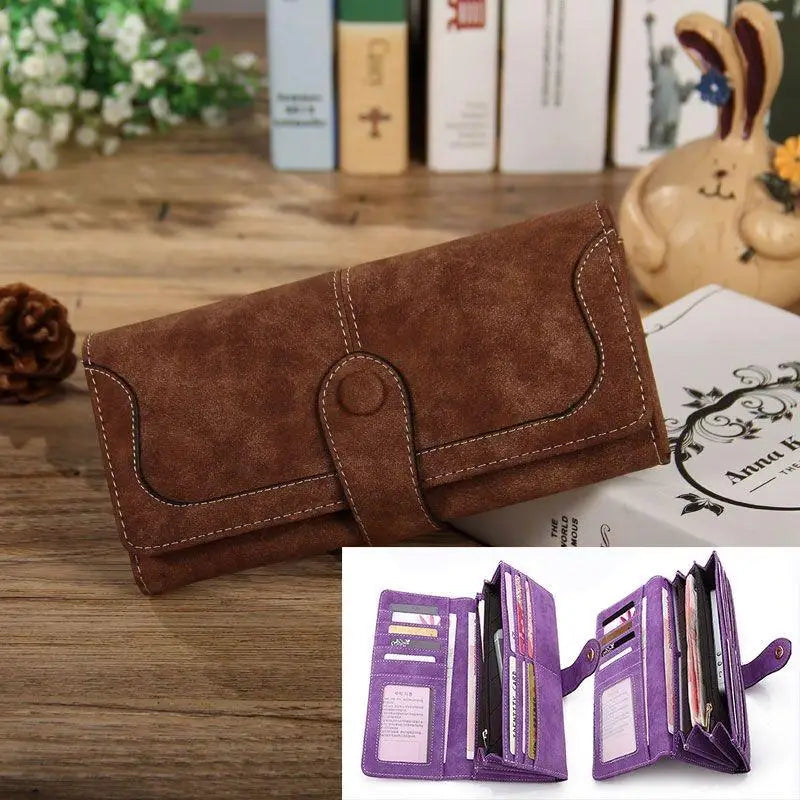 A brown PU leather clutch wallet with stitching and a flap, shown next to a stack of papers.