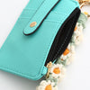 A teal silicone PU leather key chain wristlet wallet with a black zipper and a green and white floral beaded strap.