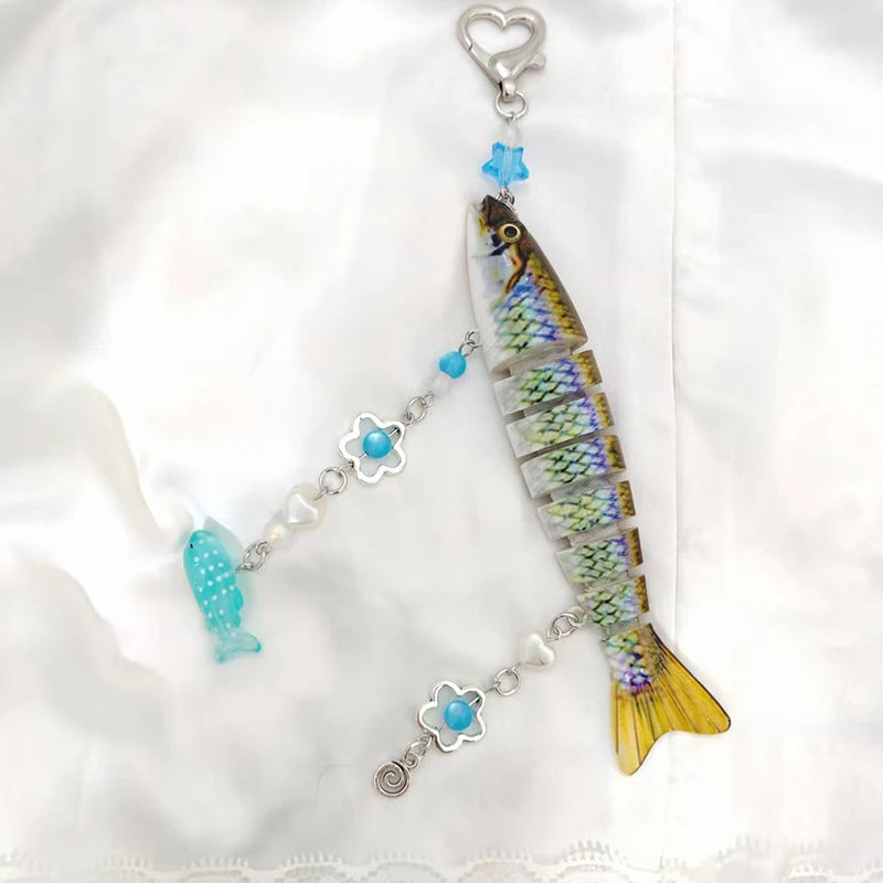 A silver acrylic keychain charm shaped like a fish with a heart loop and colorful accents.