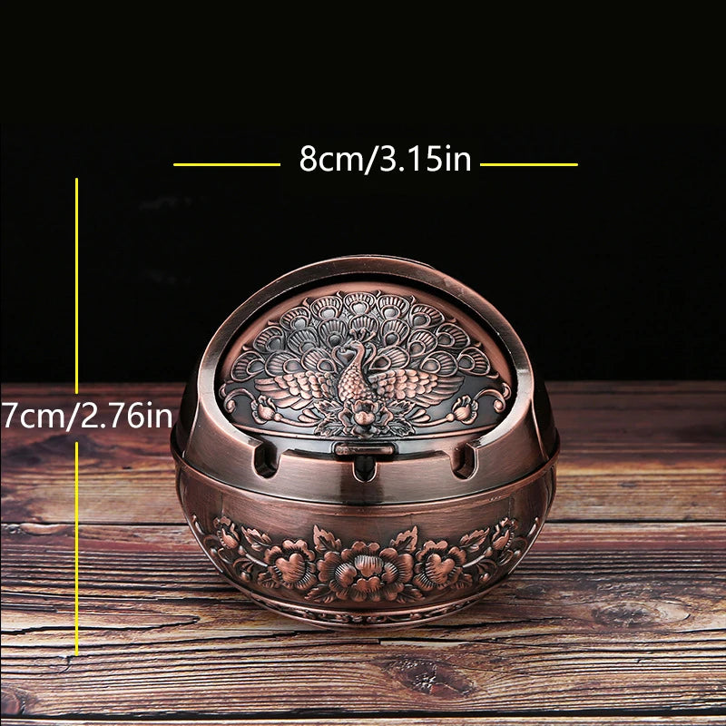 A vintage metal ashtray with a rose embossing design and windproof lid shown on a wooden surface.