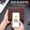 A hand holds a brown leather wallet with a smartphone displaying an RFID blocking screen.